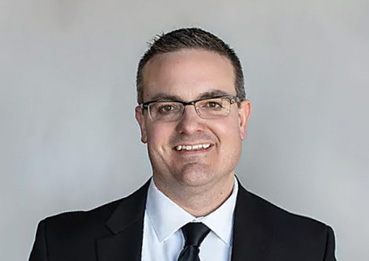 Middle-aged caucasian male with dark hair and glasses